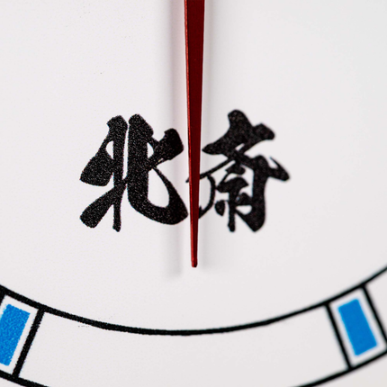 Close-up of a watch face showing black Chinese characters, a red clock hand, and part of a white dial with blue and black accents.