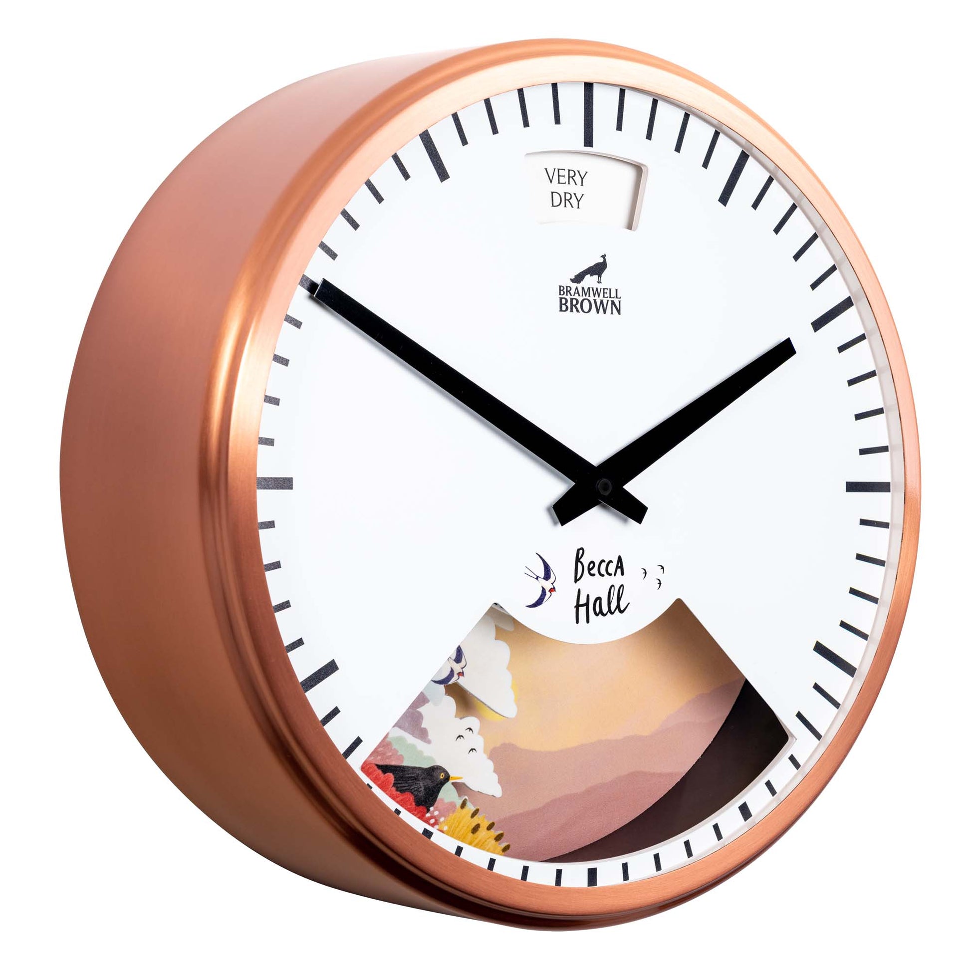 A round wall clock with a copper frame, bold black hands, and black hour markers. The lower portion displays a colorful landscape illustration, while the top shows a Very Dry weather indicator.
