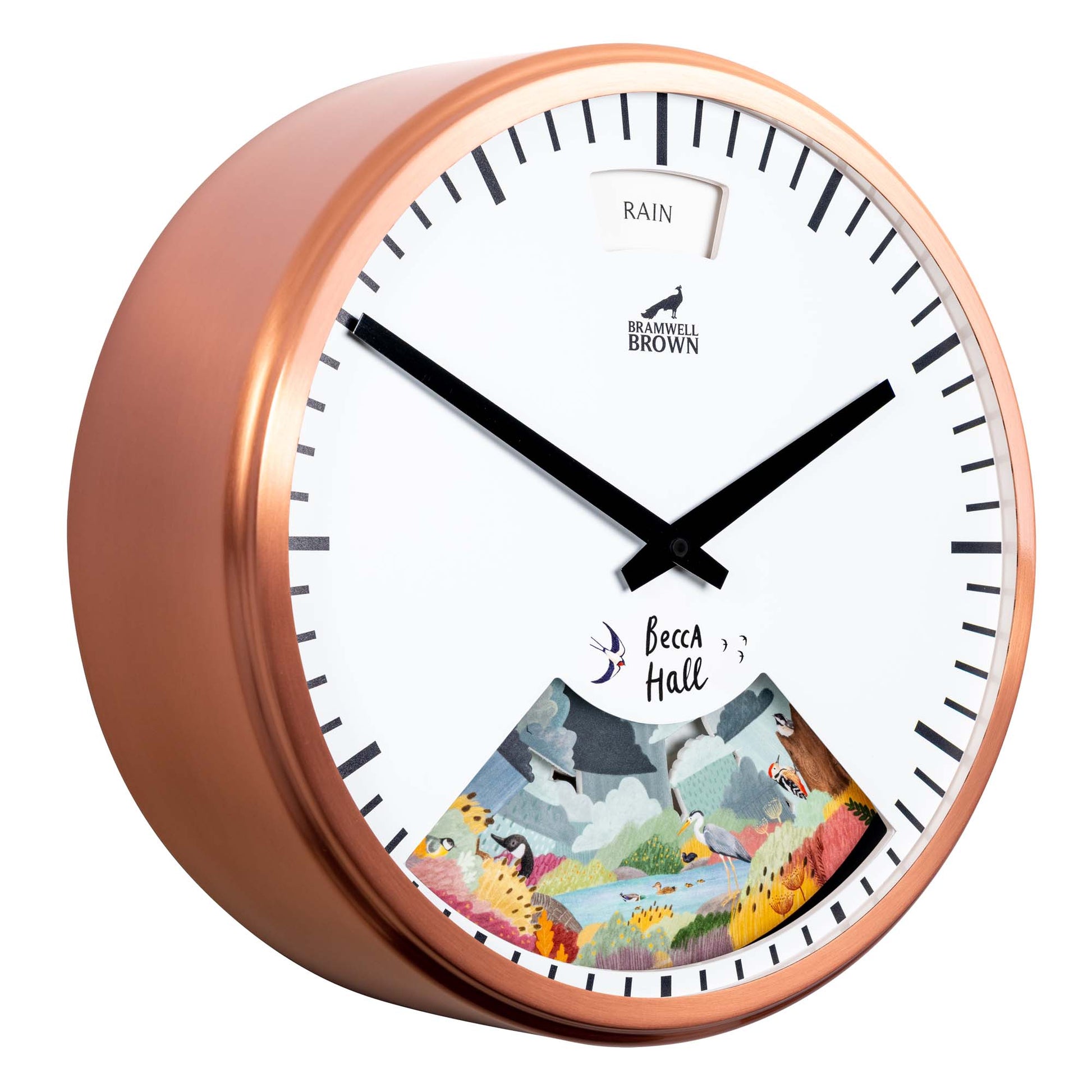 A round wall clock with a copper frame, black hands, and a white face. The clock shows Rain at the top and has a colorful illustration of a rainy landscape at the bottom, with the name Becca Hall visible.