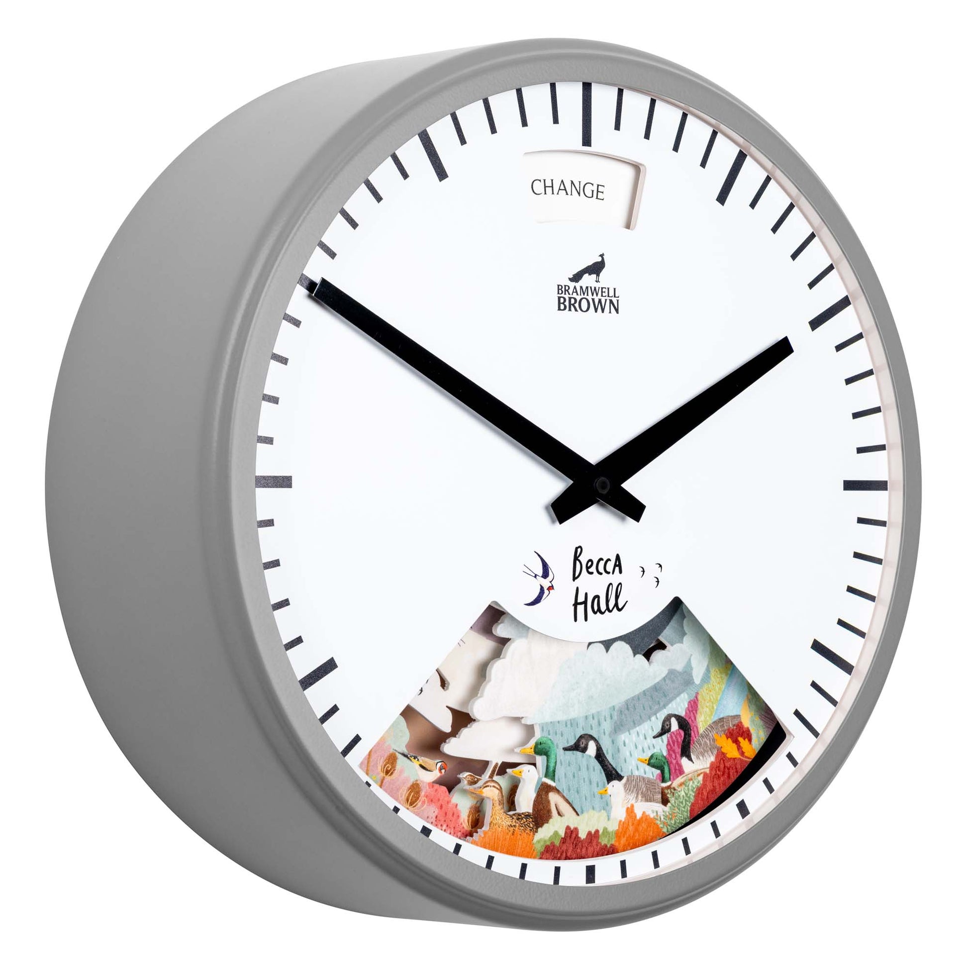 A round wall clock with a gray frame features black hour and minute hands. The clock face shows the word CHANGE at the top and an illustrated scene with animals and nature at the bottom.