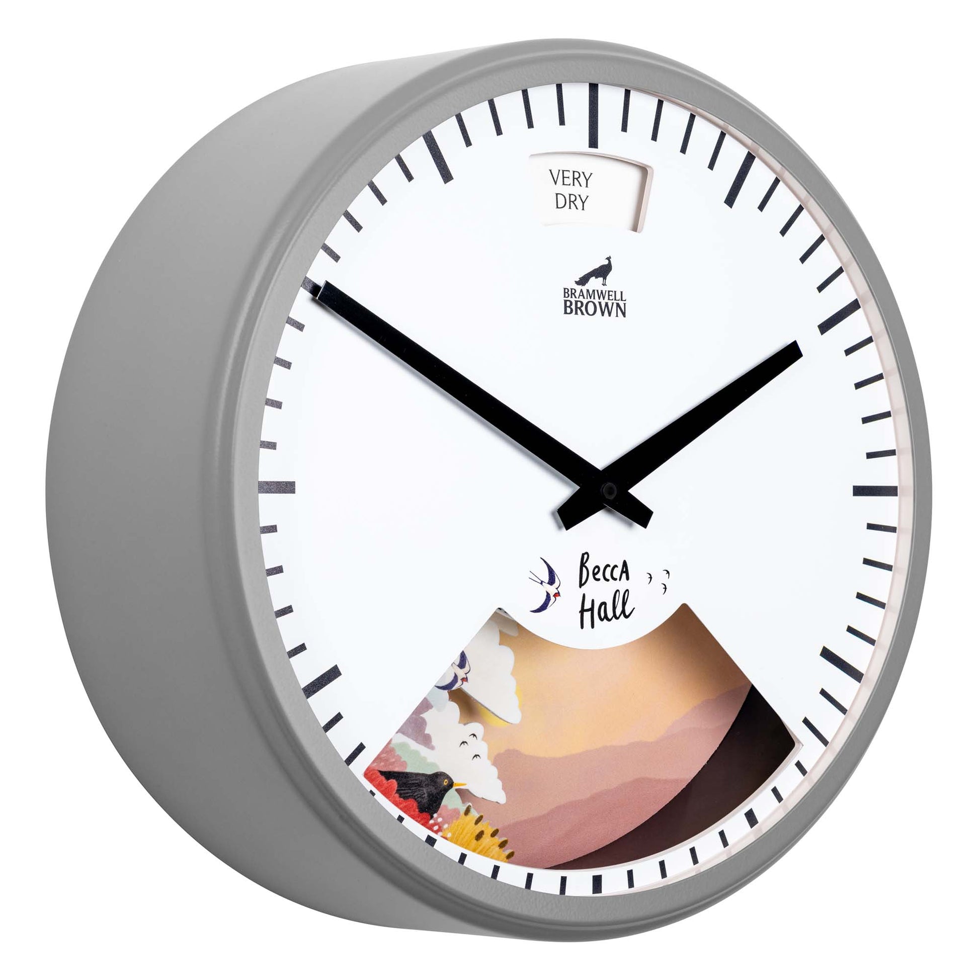 A round wall clock with a white face, black hands, and bold black hour markers. It features a small VERY DRY meter at the top and an illustrated cutout scene at the bottom labeled Becca Hall.