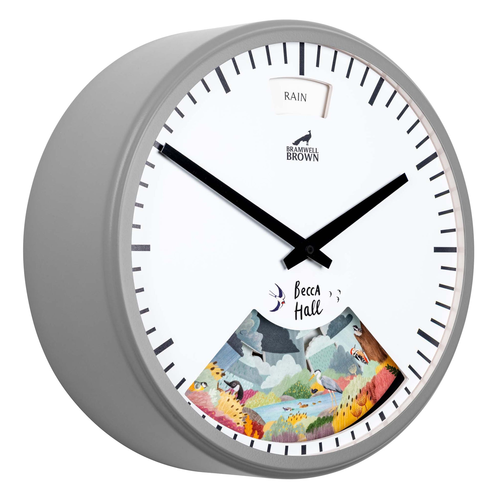 A round wall clock with a gray frame. The face features black hour and minute hands, a weather window displaying “RAIN” at the top, and a colorful illustrated scene with animals and “Becca Hall” at the bottom.