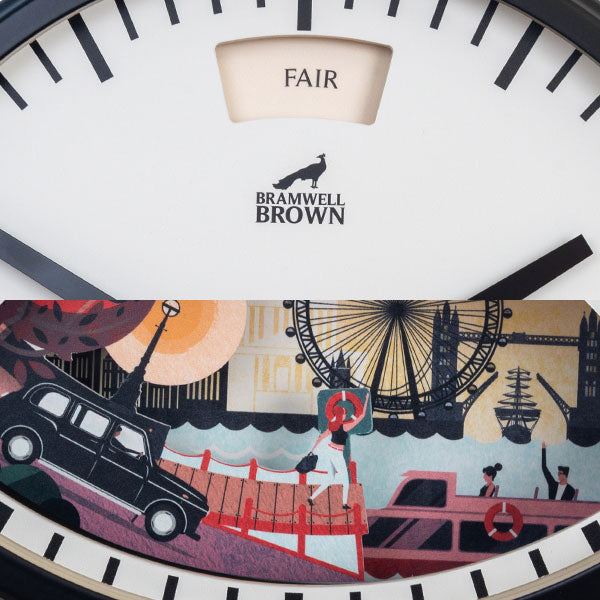 Close-up of a Bramwell Brown clock featuring London-themed artwork with a black taxi, red double-decker bus, Thames river, boats, and the London Eye beneath the clock hands. The word FAIR appears at the top.