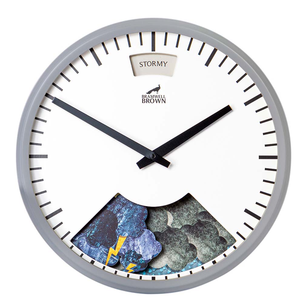 Analog wall clock with a gray frame, black hour and minute hands, and a weather display showing STORMY at the top and storm clouds with a yellow lightning bolt at the bottom. The brand Bramwell Brown is visible on the face.